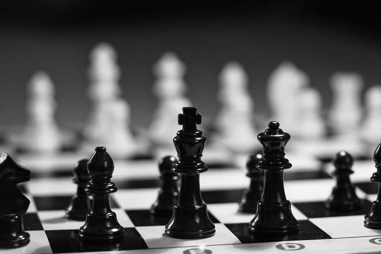 A back and white image of a chess borad and chess pieces